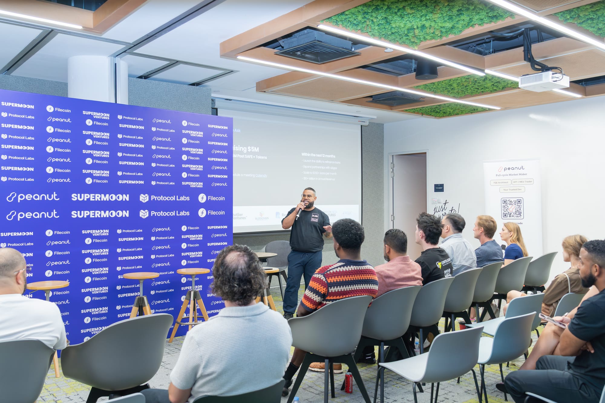 ChatGPT said:  The image shows a speaker addressing an audience during Startup Day at Token2049 Singapore, hosted by Supermoon, Peanut, Protocol Labs, and Filecoin.