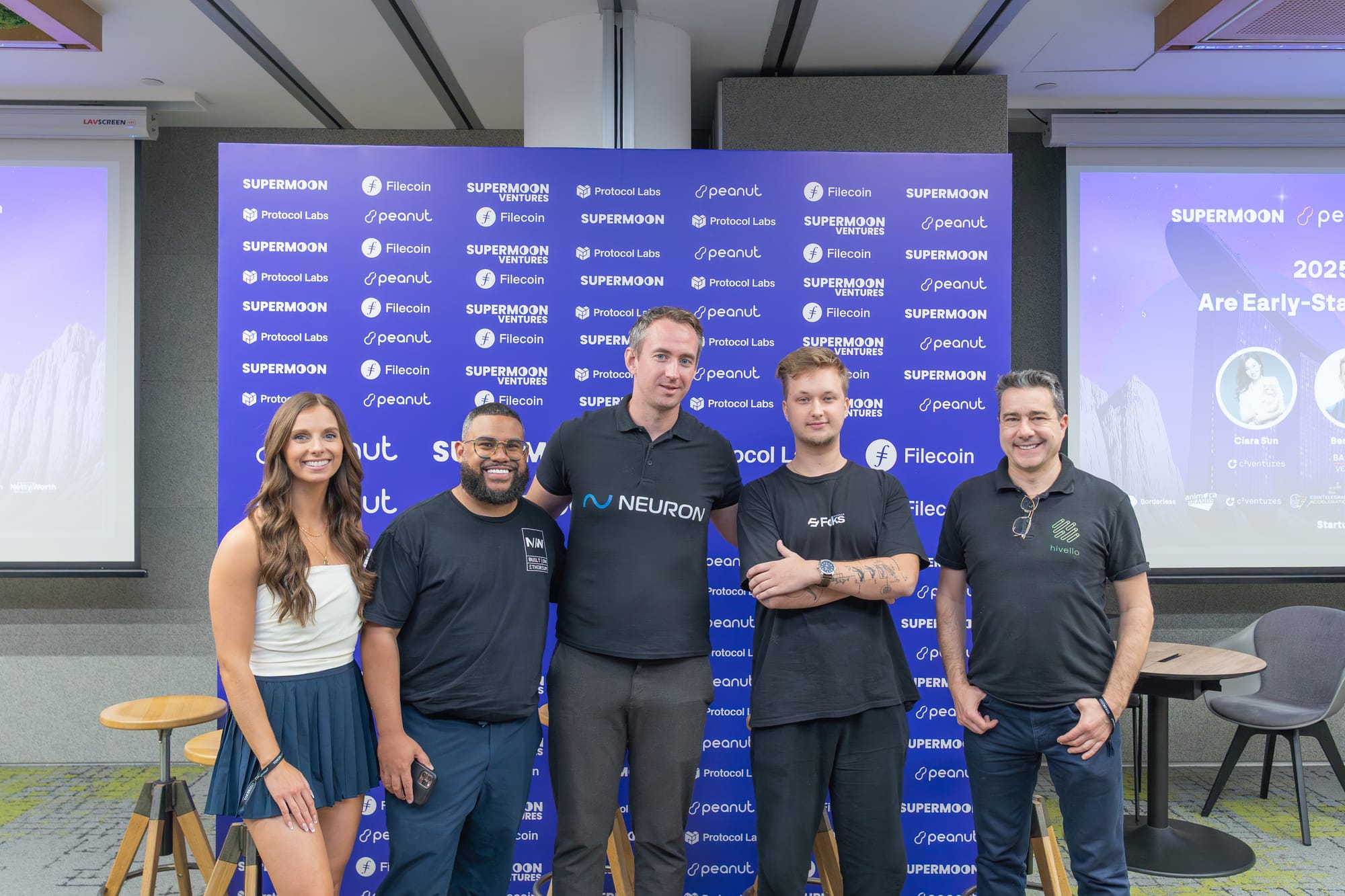 The image shows a group of five startup founders and speakers posing together at Startup Day during Token2049 Singapore. They stand in front of a branded backdrop featuring the event’s main partners