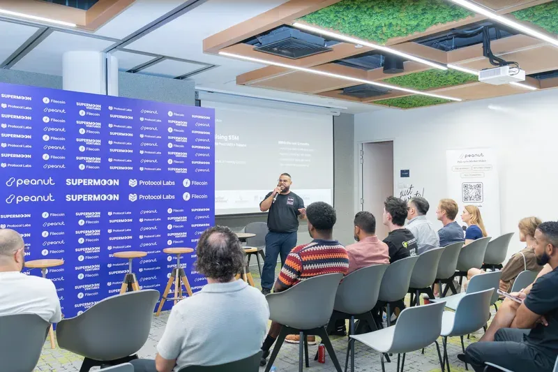 ChatGPT said: The image shows a speaker addressing an audience during Startup Day at Token2049 Singapore, hosted by Supermoon, Peanut, Protocol Labs, and Filecoin.